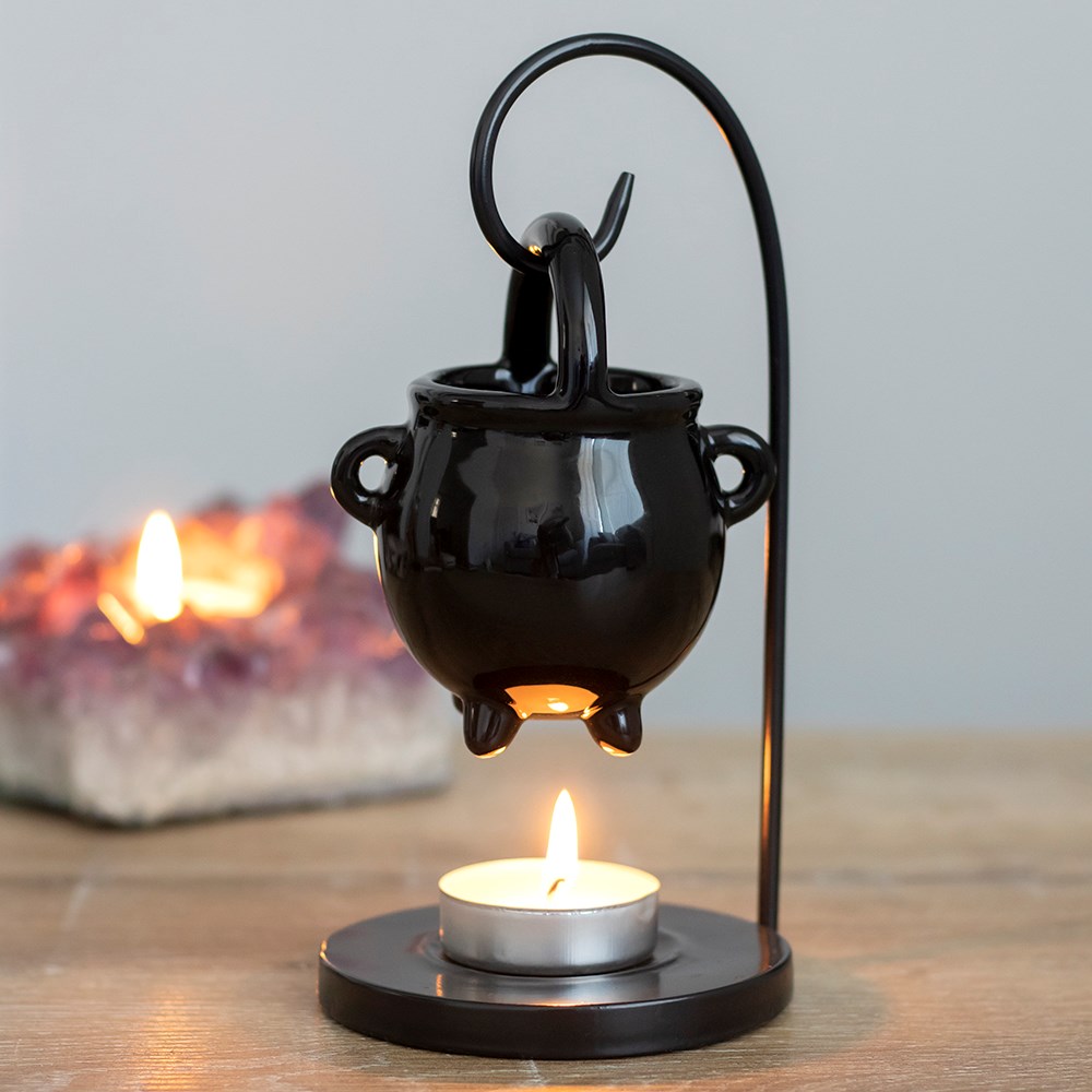 Brûle-parfum chaudron noir suspendu à un support au-dessus d’une bougie chauffe-plat